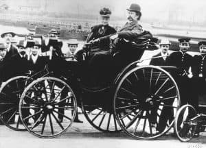 Karl Benz com sua esposa, Bertha Benz, em um modelo Benz Victoria de 1894 Foto por Fronteras sob CC BY-SA 4.0 disponível em Wikimedia Commons.